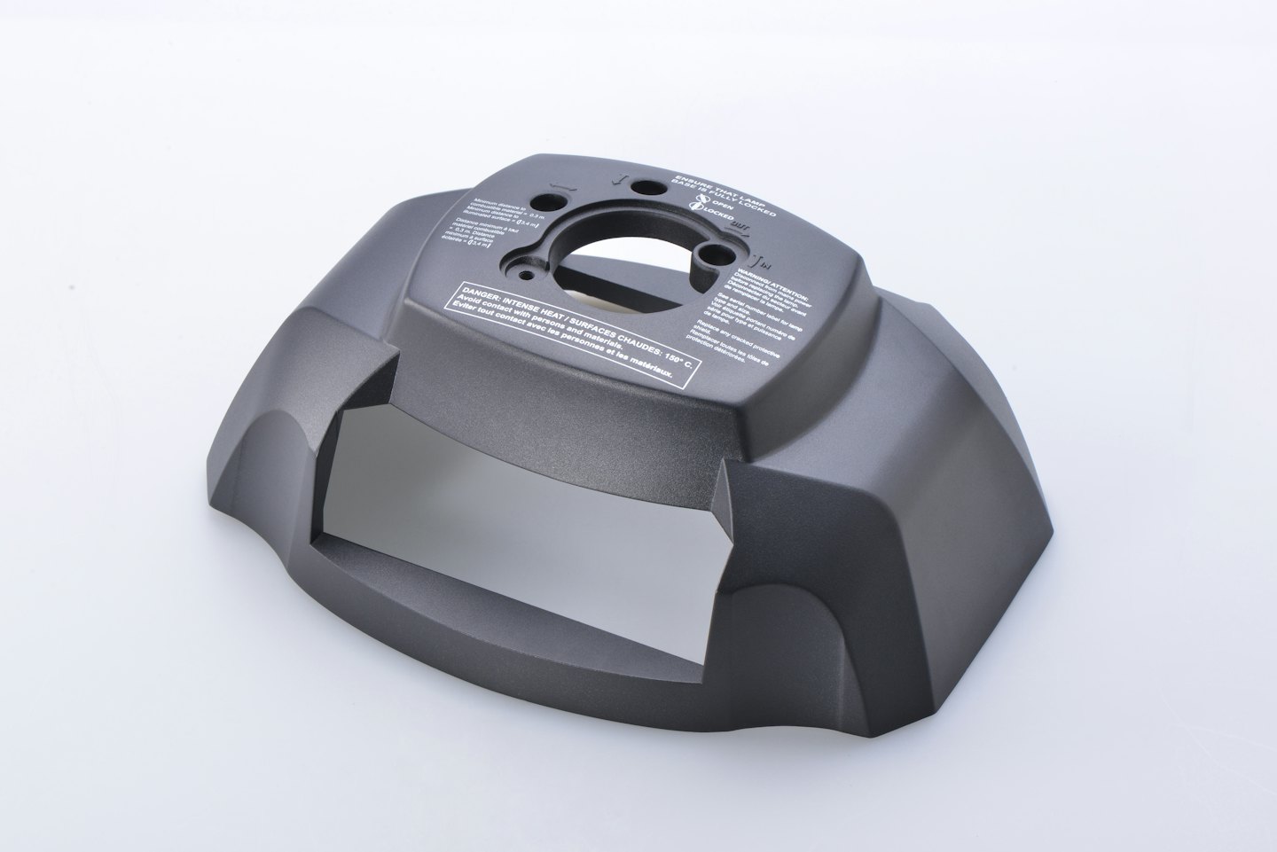 Copertura in plastica grigio scuro stampata per macchinari con etichette di avvertenza multilingue.